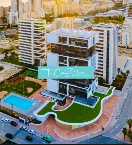 A building with a garden and a pool in Calpe, adjacent to many other buildings.