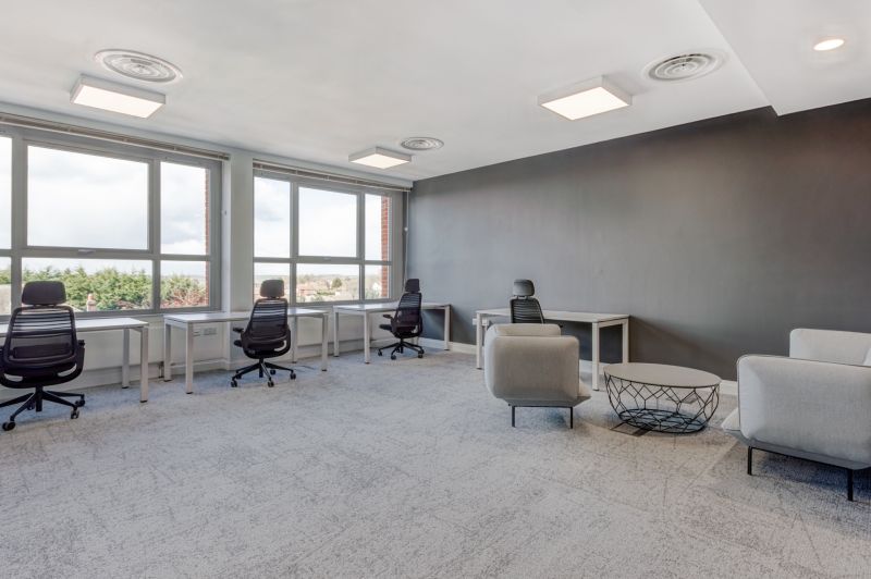 Offices with large windows, gray walls, and modern furniture.