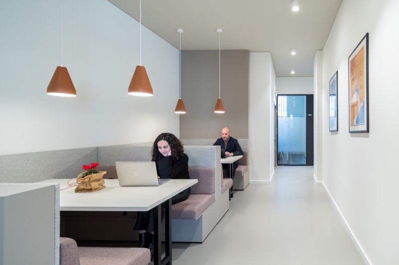 Offices with sofas and laptops, minimalist lighting and wall decorations.