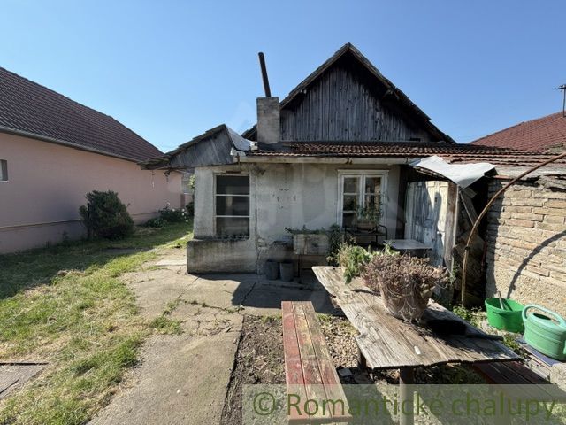 Older family house in Šurany with wooden decor and a garden.