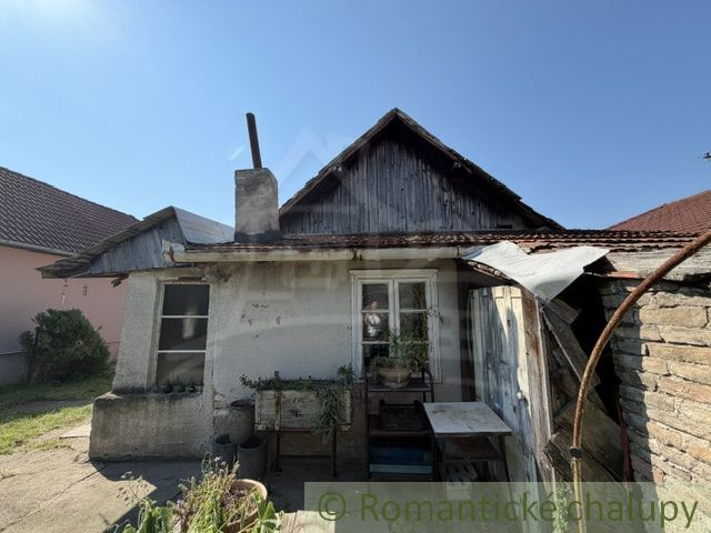 An older family house in Šurany with a wooden roof and a chimney.