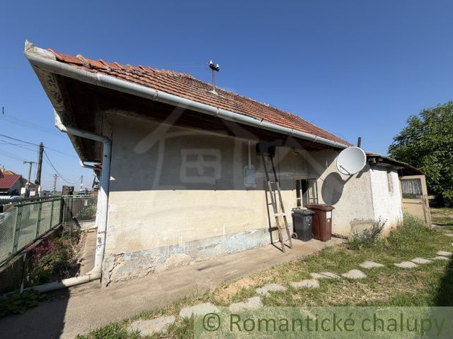 A family house in Šurany with a red roof and a satellite dish.