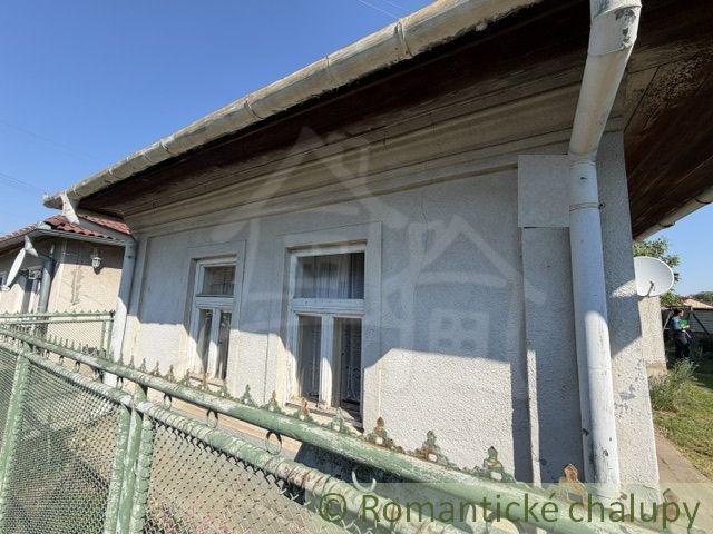 A family house in Šurany with older windows and a metal fence.