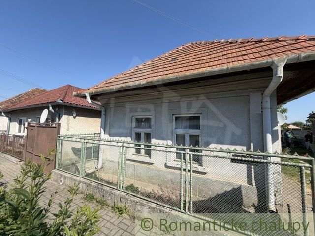 A family house in Šurany with a traditional gable roof and a simple fence.