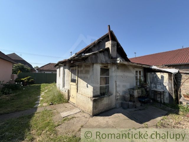 An older family house in Šurany with a stone facade and an extension.
