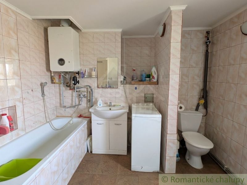 Bathroom with shower, bathtub, and washing machine in a 2-room apartment.