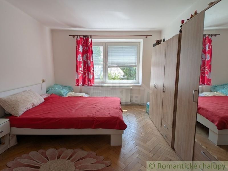 Bedroom in a 2-room apartment with a bed, wardrobe, and floor with wood decor.