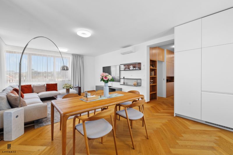 Bright living room with wood-patterned flooring and a comfortable corner sofa.