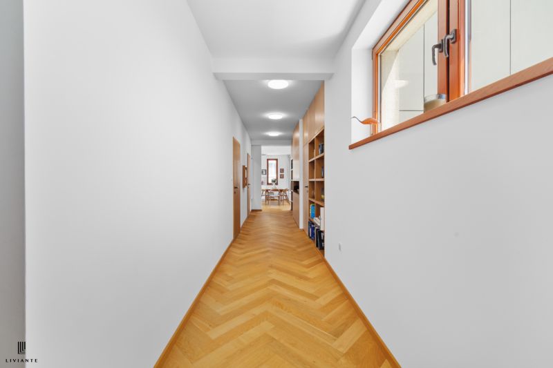 A hallway with a built-in bookshelf and a wooden decor floor in a 4-room apartment.