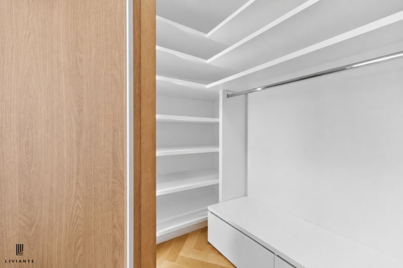 A wardrobe room in a 4-room apartment with shelves and a floor with a wooden decor.