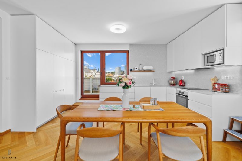 A kitchen in a 4-room apartment with white cabinets and a wood-patterned floor.