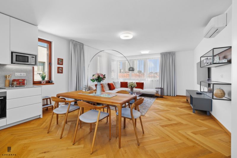 Living room in a 4-room apartment with a wooden decor floor and a large dining table.