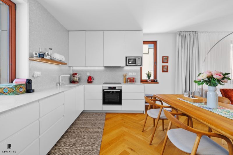 A kitchen in a 4-room apartment with white cabinets and a wood-patterned floor.