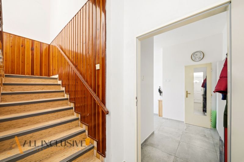 A staircase with wooden paneling and a mirror in a family house.