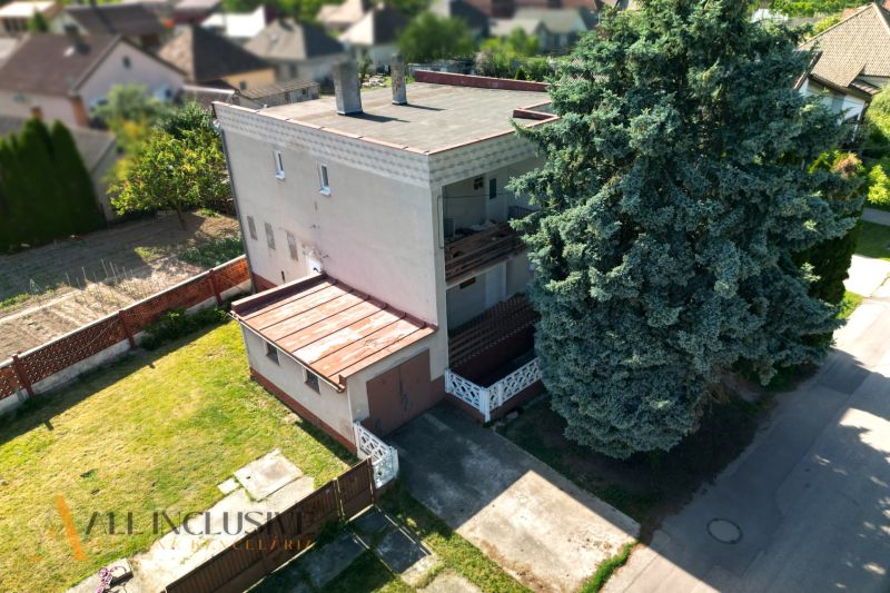 A family house in Topoľníky surrounded by a garden and a large tree on the driveway.