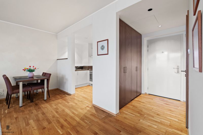 2-room apartment with wood-patterned flooring, a dining table, and a built-in wardrobe.