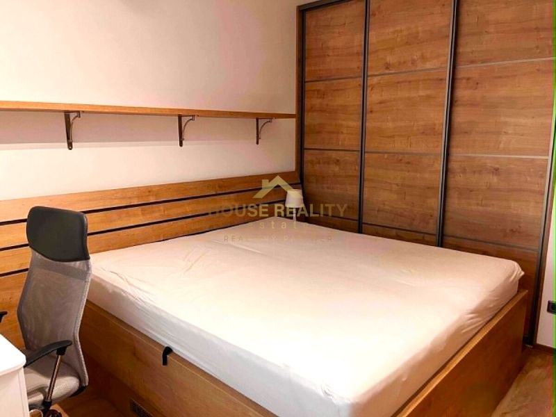 Bedroom with a bed and a built-in wardrobe, in a 2-room apartment.