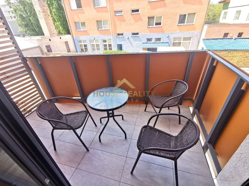 A balcony in a 2-room apartment with three chairs and a table.