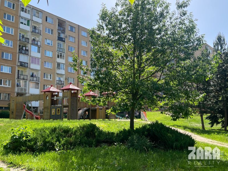Apartment building and children's playground surrounded by greenery on Juhoslovanská, Košice - Sídlisko Ťahanovce.