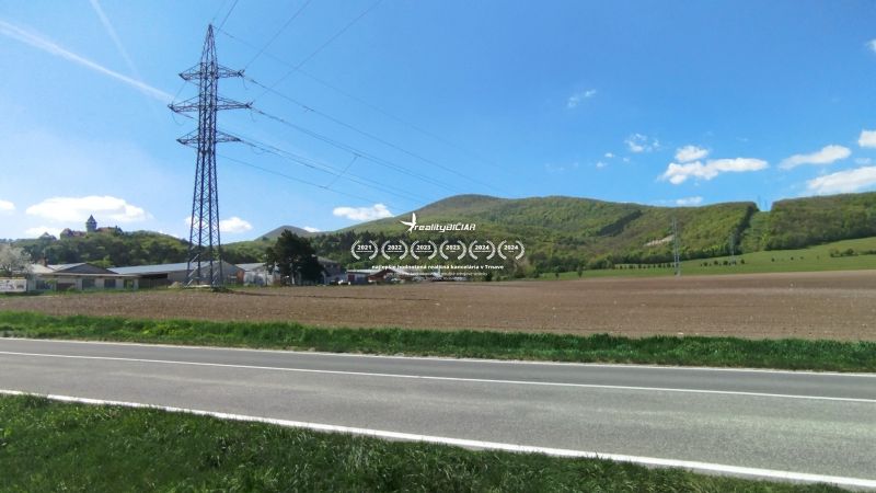 Landscape on Továrenská in Smolenice with agricultural and forest lands and power lines.