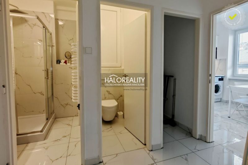 The interior of the bathroom and toilet in a 2-room apartment with marble-patterned tiles.