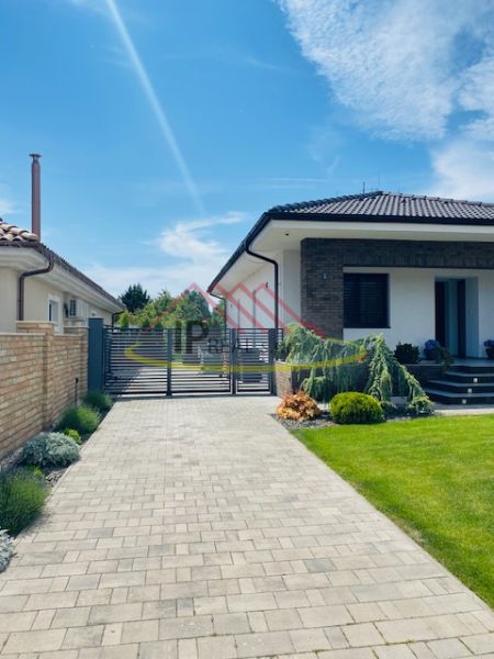 A family house on Jasná Street in Veľké Dvorníky with a landscaped garden and an entrance gate.
