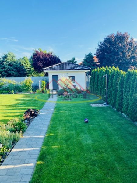 A well-maintained lawn and pathway next to a family house on Jasná Street in Veľké Dvorníky.
