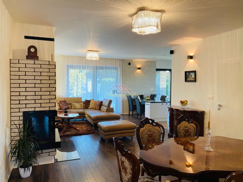 Living room in a family house with wood-patterned flooring and a fireplace, elegant dining room.