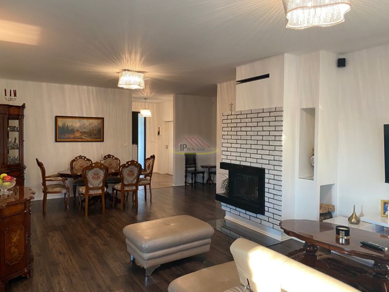 Living room in a family house with a fireplace and a wooden decor floor.