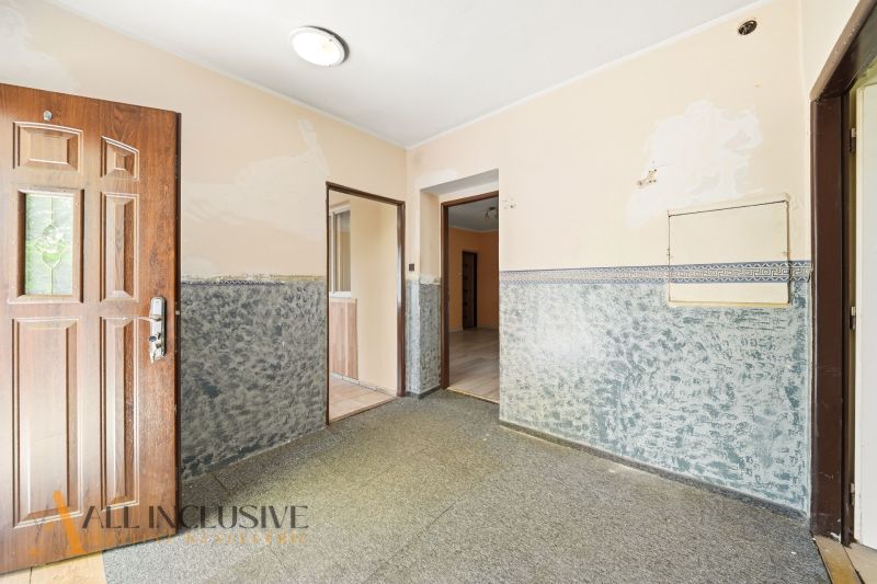 A hallway in a family house with light walls and open doors.