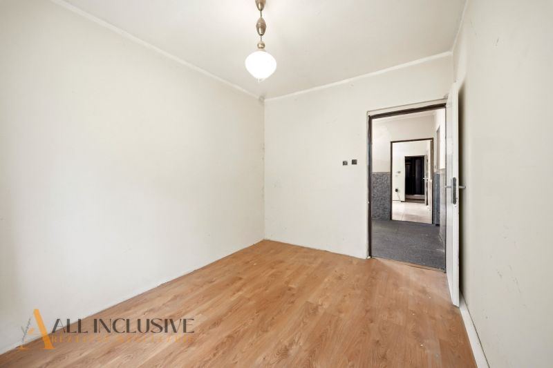 A room in a family house with white walls and a wooden decor floor.