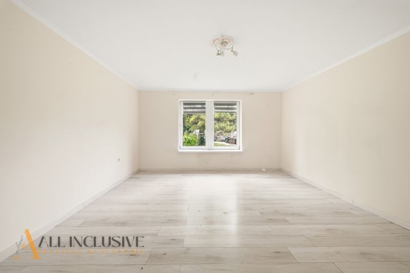 A spacious room with a wooden decor floor in a family house.