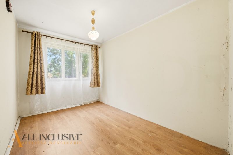 A room in a family house with a window, curtains, and a floor with a wooden decor.