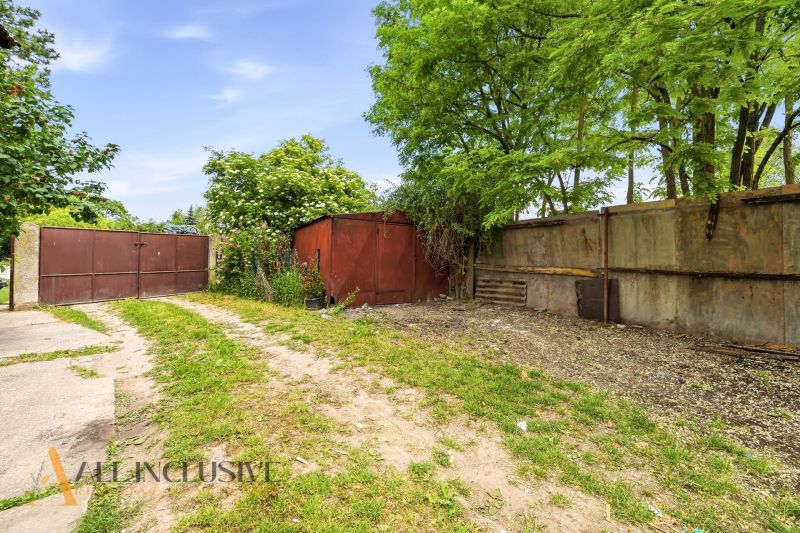 The garden of a family house in Lehnice with a metal gate and greenery.
