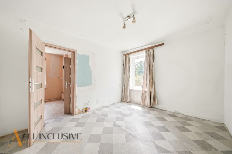 A room with dull curtains and doors, and a checkered pattern floor in a family house.