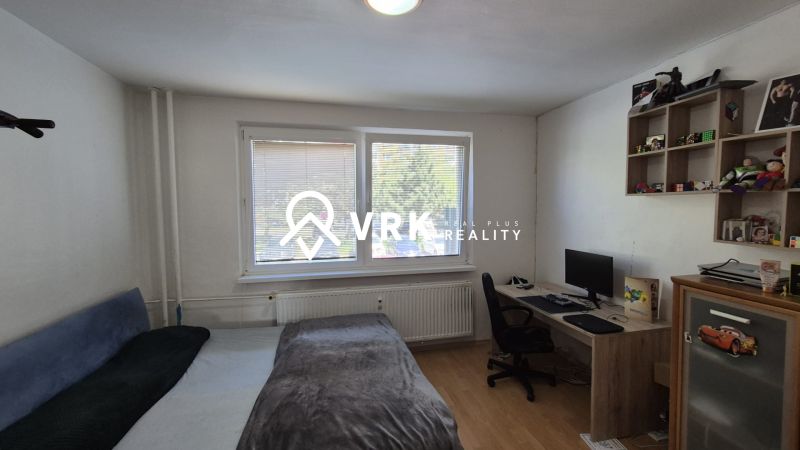 A room in a 3-room apartment with a bed, a desk, and a floor with a wooden decor.