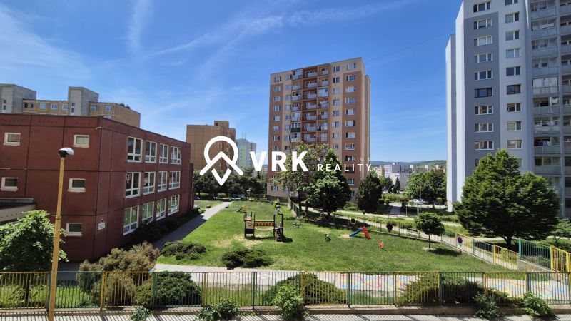 Sídlisko Ťahanovce, Belehradská: Apartment buildings surrounded by greenery and a playground in a sunny setting.