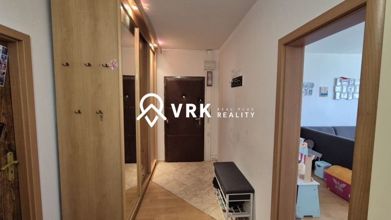 A hallway with a coat rack and a mirror in a 3-room apartment. Floor with a wooden decor.