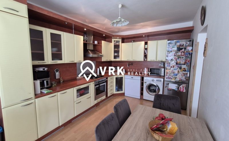 A kitchen with a corner countertop and a wooden decor floor in a 3-room apartment.
