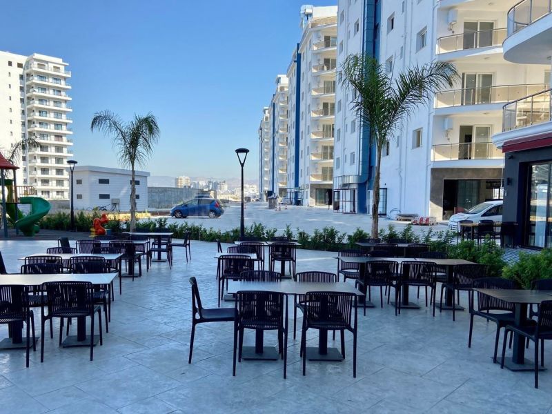 Iskele are visible outdoor spaces with café tables and high-rise buildings.