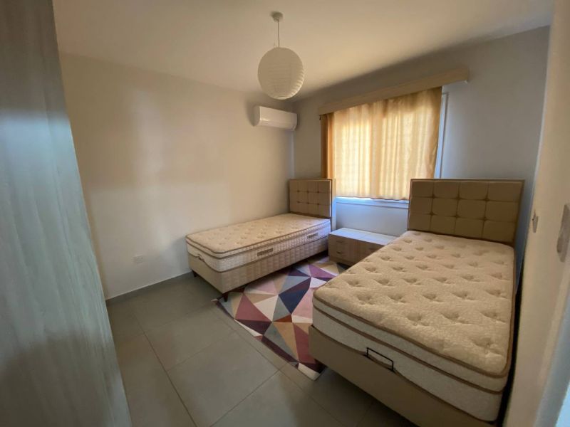 Children's room with two beds, a carpet, and curtains in a 3-room apartment.