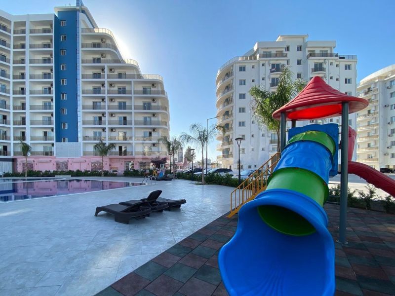 Playground and swimming pool near residential buildings in the city of Iskele.