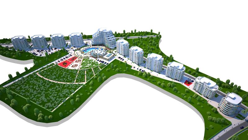 A resort with a complex of buildings, greenery, and a swimming pool near the town of Iskele.