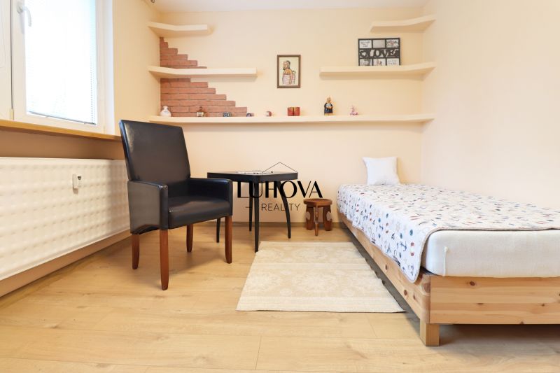 Bedroom in a 3-room apartment with a bed, chair, table, and floor with wooden decor.
