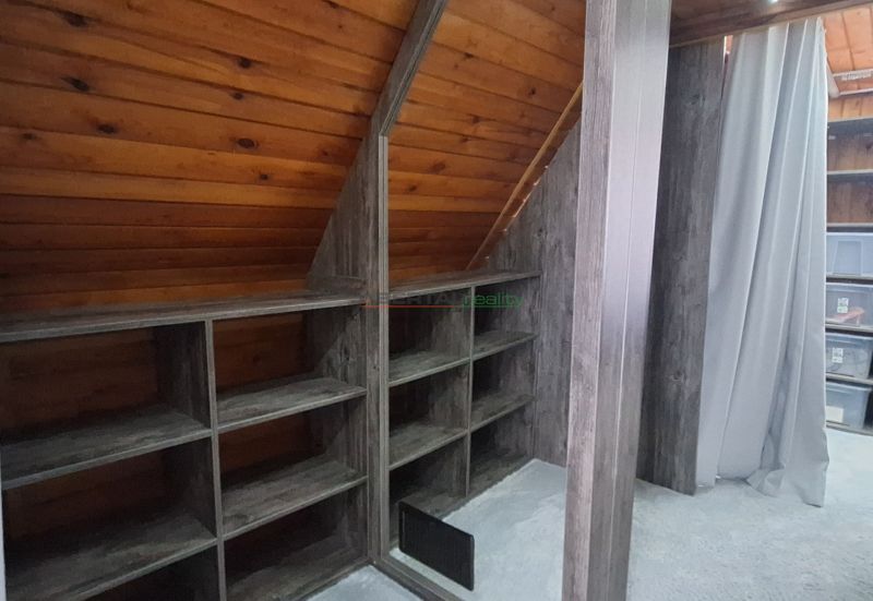 A folding roof of a room with wooden decor and shelves in a cabin.