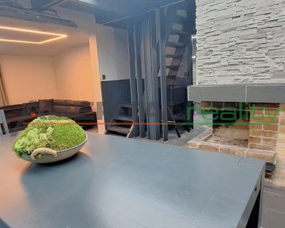 Interior of a cabin with a fireplace, table, and lichen decoration.