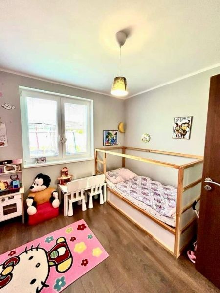 Children's room with a bed, toys, and floor decor in a family house.