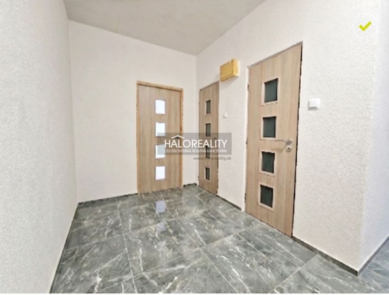 A hallway with a marble floor and doors in a two-room apartment.