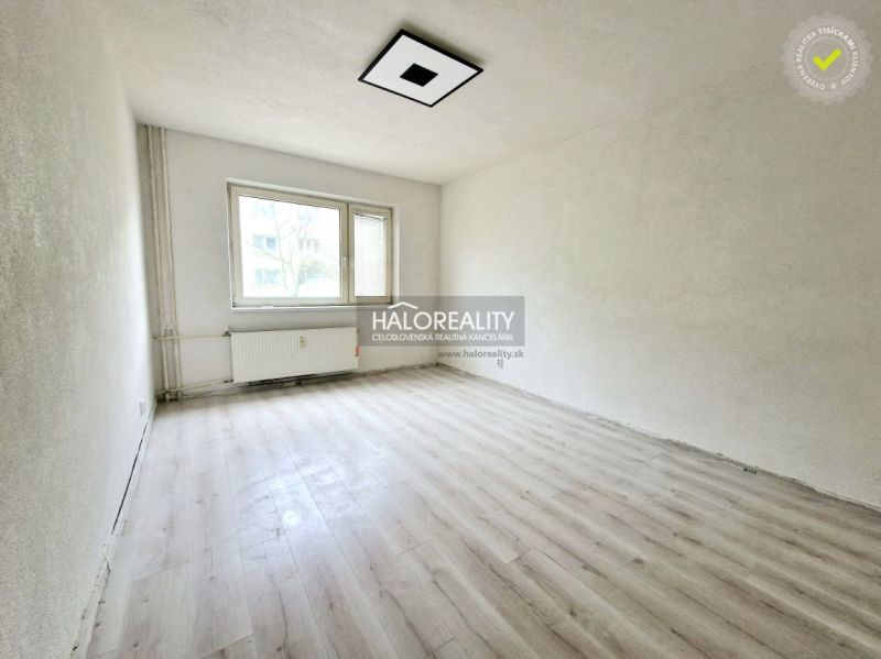 A room with a window and a radiator, a floor with a wooden decor in a 2-room apartment.