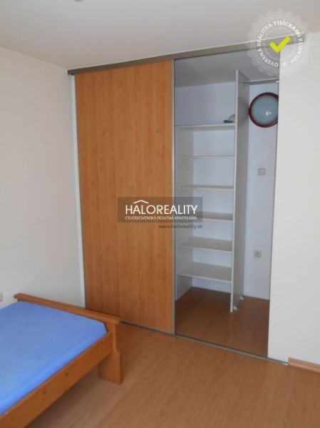 Interior of a 3-room apartment with a bed and built-in wardrobe, floor with wood decor.
